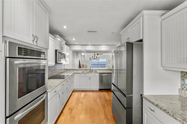 a view of a kitchen with stainless steel appliances granite countertop a sink refrigerator and microwave