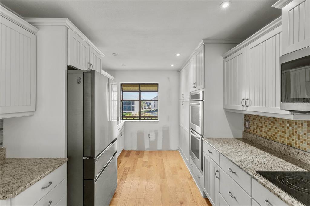 3840 Mariners Way, Unit 525 Cortez, FL 34215 - Photo 8 of 48 a kitchen with stainless steel appliances granite countertop a refrigerator and a stove top oven