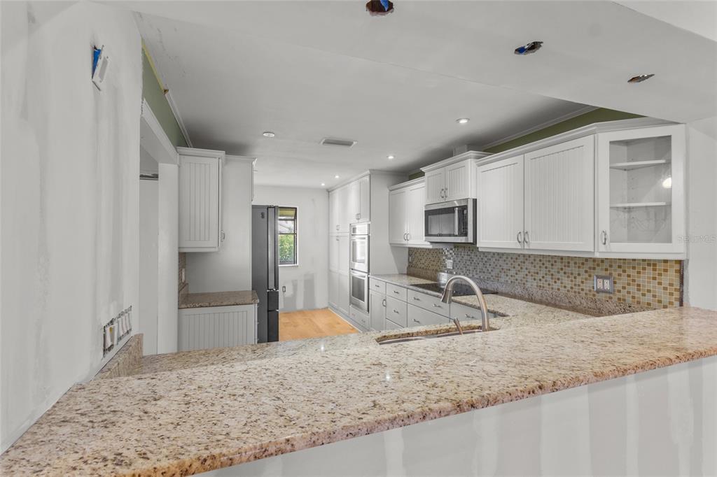3840 Mariners Way, Unit 525 Cortez, FL 34215 - Photo 10 of 48 a view of a kitchen with stainless steel appliances granite countertop a sink refrigerator and microwave