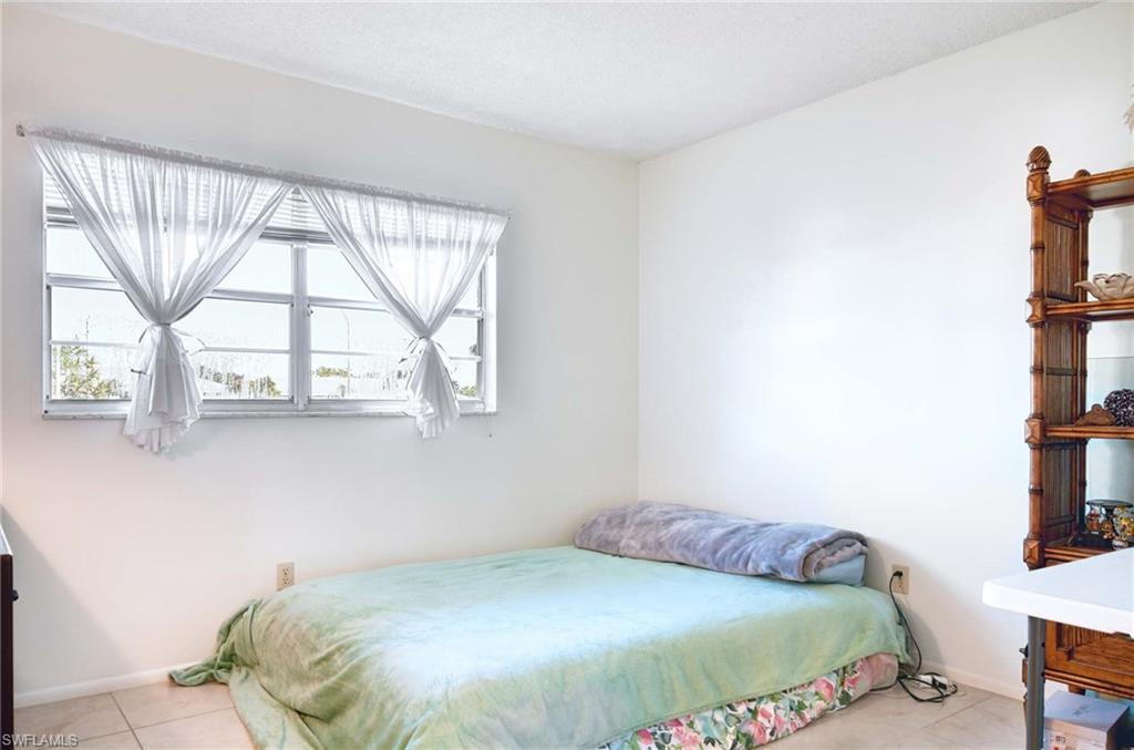 5483 Rattlesnake Hammock Road, Unit 207 Naples, FL 34113 - Photo 12 of 15 Bedroom featuring light tile patterned floors