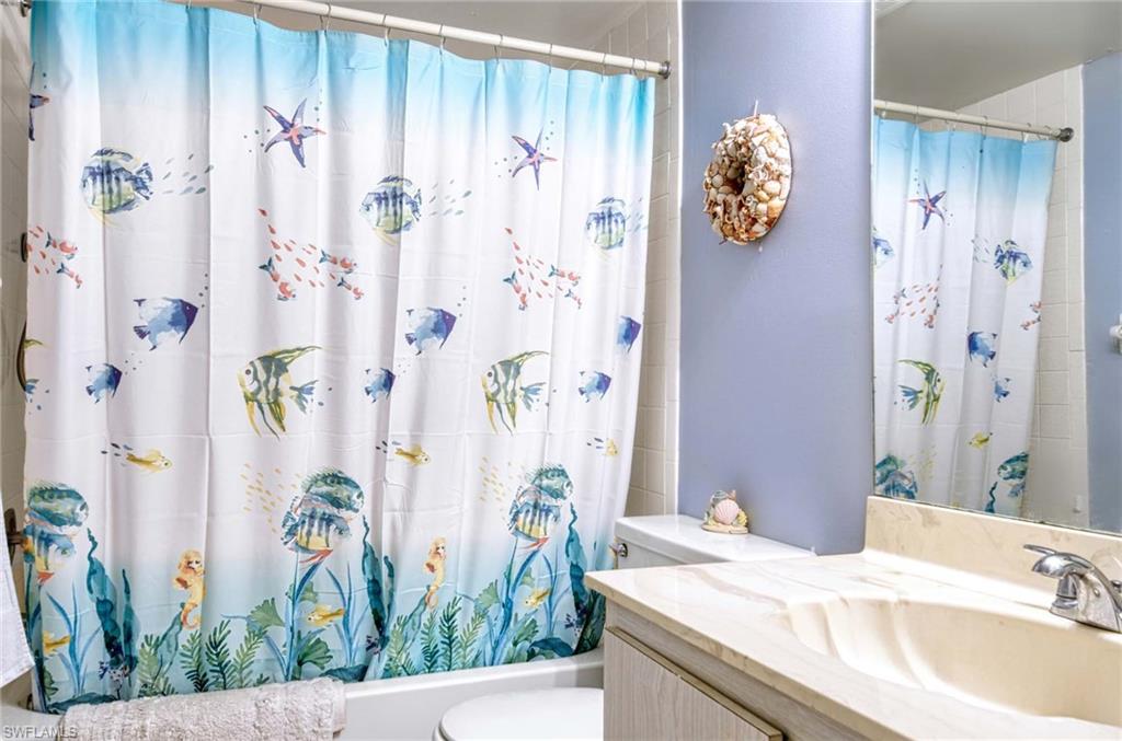 5483 Rattlesnake Hammock Road, Unit 207 Naples, FL 34113 - Photo 13 of 15 Full bathroom featuring vanity and shower / bath combo with shower curtain