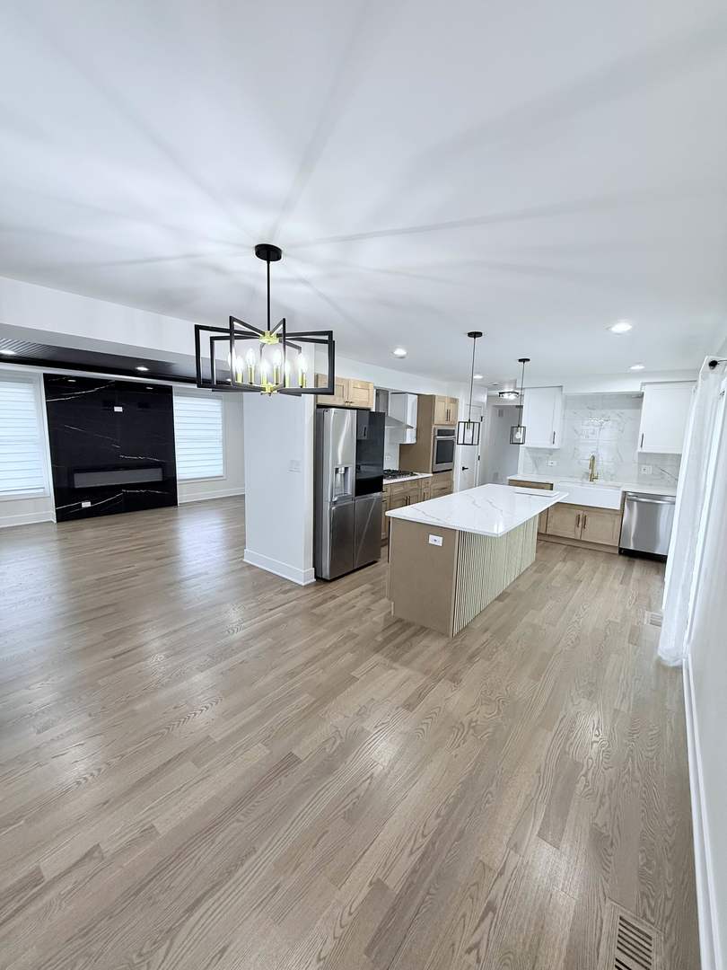 1581 Groton Lane Wheaton, IL 60189 - Photo 5 of 15 a living room with stainless steel appliances kitchen island granite countertop a sink cabinets and wooden floor