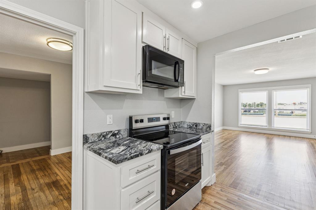 3226 Inwood Road Dallas, TX 75235 - Photo 12 of 25 a kitchen with stainless steel appliances granite countertop a stove and a microwave