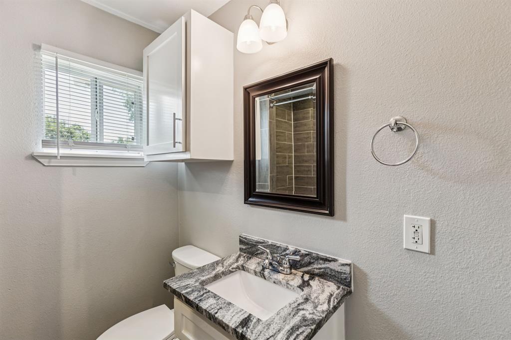 3226 Inwood Road Dallas, TX 75235 - Photo 14 of 25 a bathroom with a toilet a sink and mirror