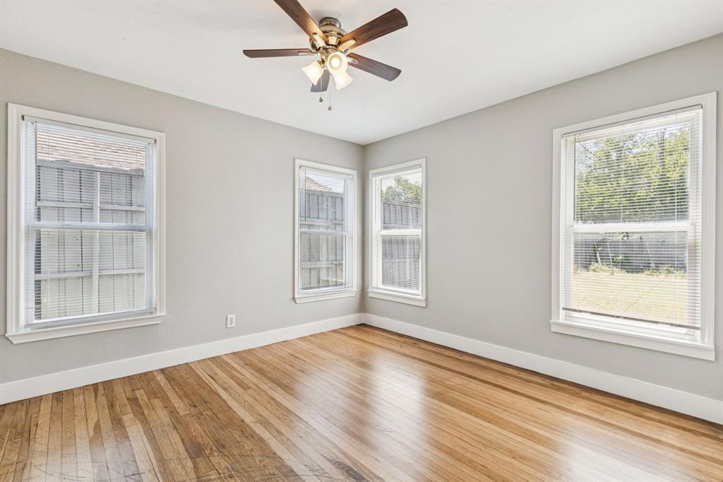 3226 Inwood Road Dallas, TX 75235 - Photo 15 of 25 a view of an empty room with a window and wooden floor
