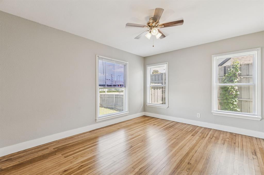 3226 Inwood Road Dallas, TX 75235 - Photo 17 of 25 a view of an empty room with a window and wooden floor