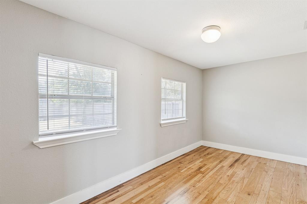 3226 Inwood Road Dallas, TX 75235 - Photo 18 of 25 an empty room with wooden floor and windows