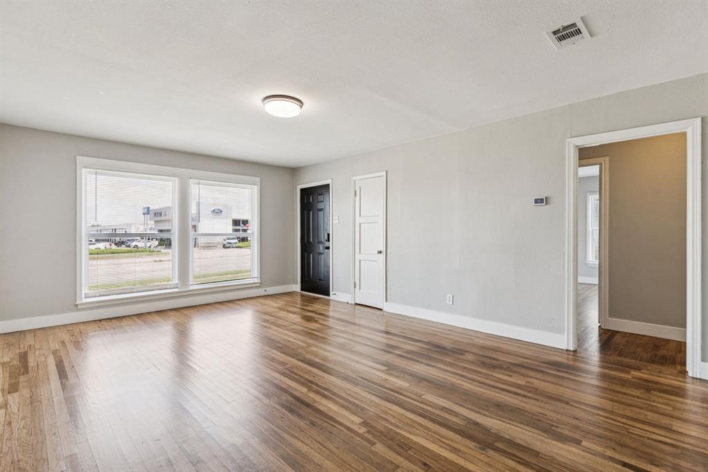 3226 Inwood Road Dallas, TX 75235 - Photo 8 of 25 a view of an empty room with wooden floor and a window