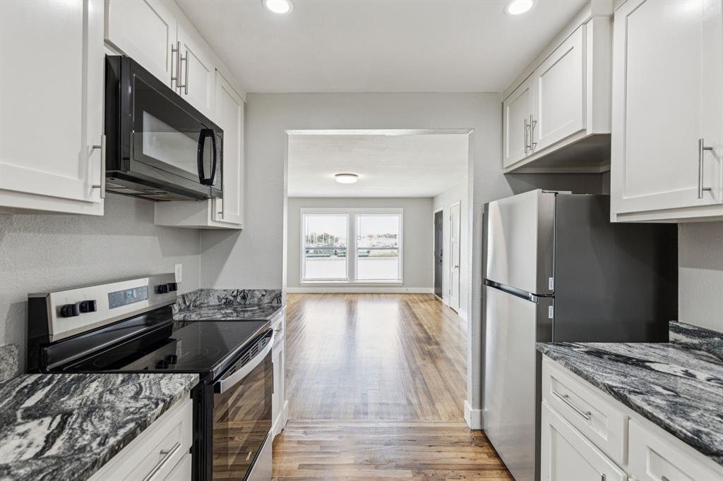 3226 Inwood Road Dallas, TX 75235 - Photo 10 of 25 a kitchen with stainless steel appliances a stove a sink and a refrigerator