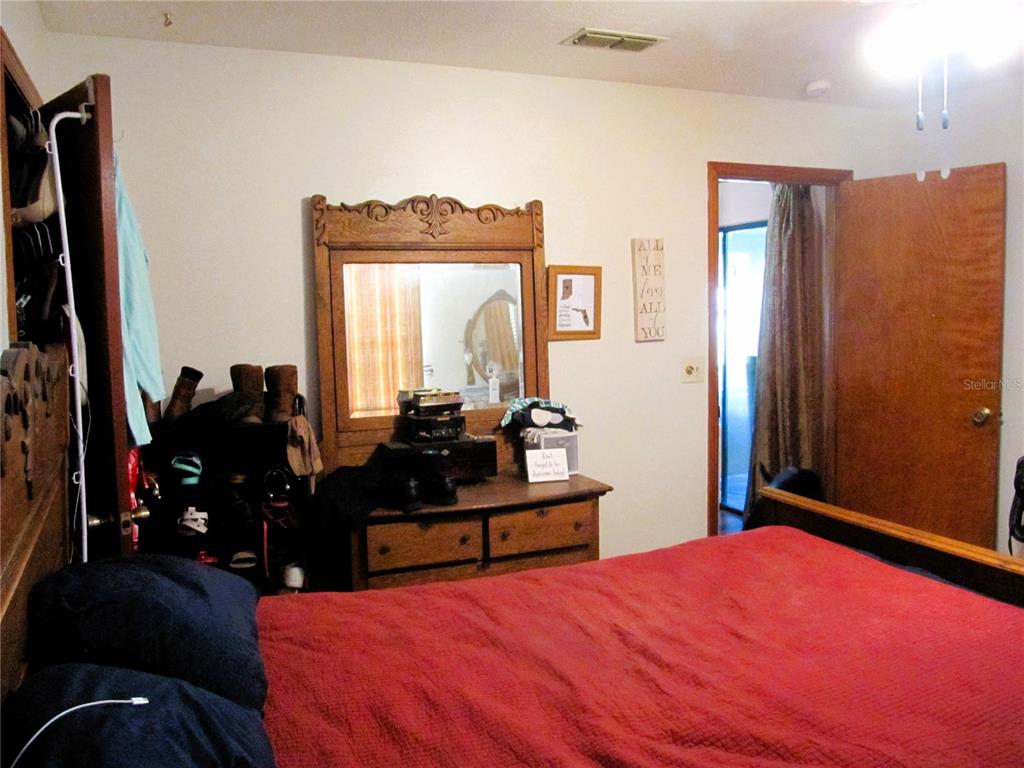 11815 Southeast 84 Avenue Belleview, FL 34420 - Photo 17 of 23 a bed room with a bed mirror and dresser
