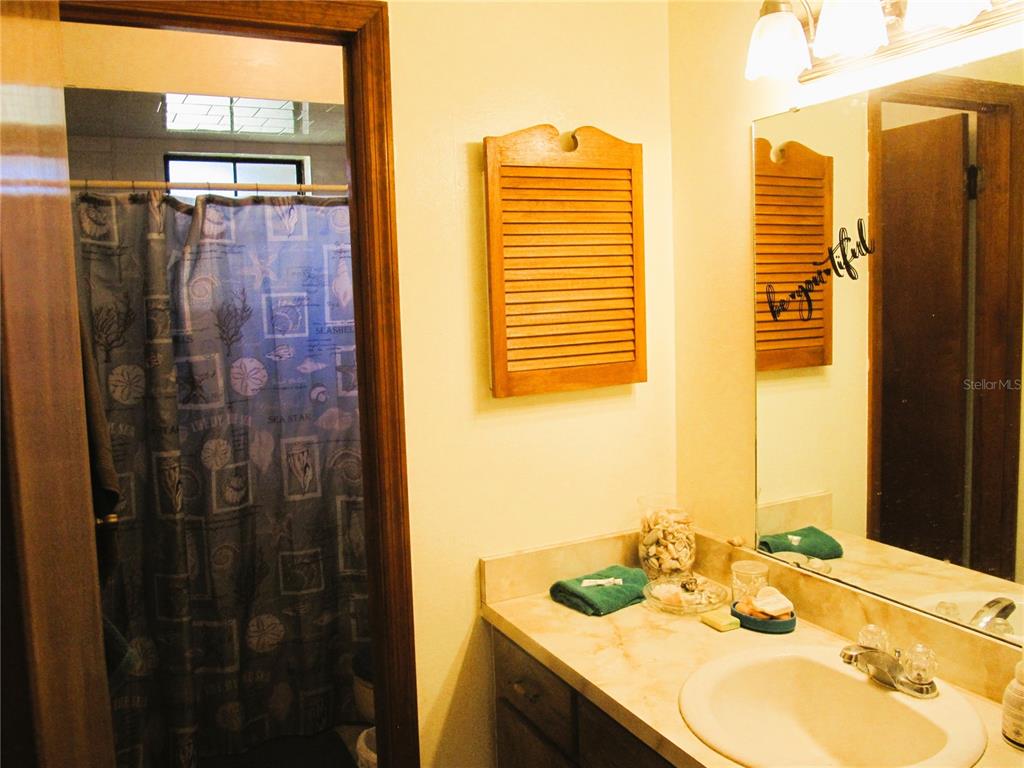 11815 Southeast 84 Avenue Belleview, FL 34420 - Photo 18 of 23 a bathroom with a granite countertop sink and a mirror