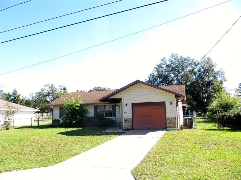 11815 Southeast 84 Avenue Belleview, FL 34420 - Photo 4 of 23 a front view of a house with a garden and trees