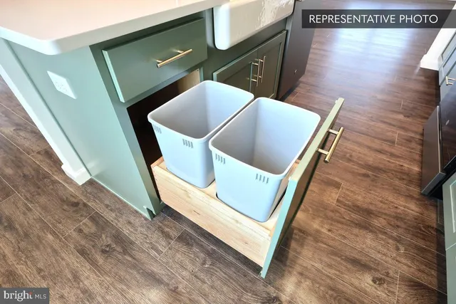 a view of an empty room with wooden floor and staircase