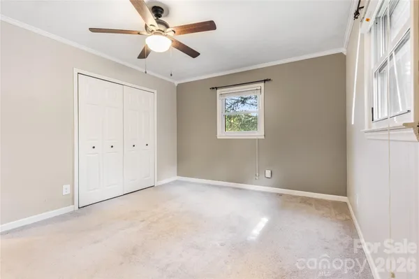 an empty room with windows and fan