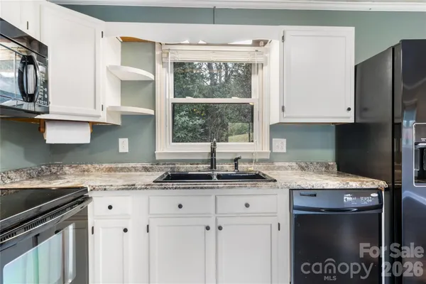 a kitchen with stainless steel appliances granite countertop a sink stove and cabinets