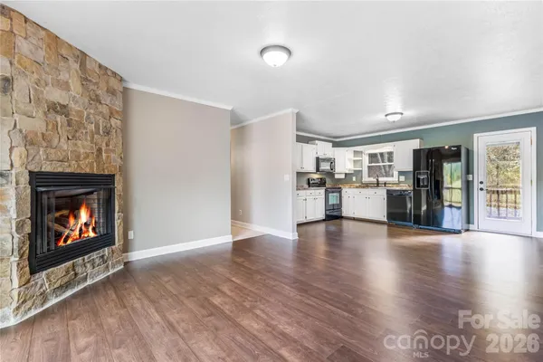 a view of a kitchen with a fireplace wooden floor and a kitchen space