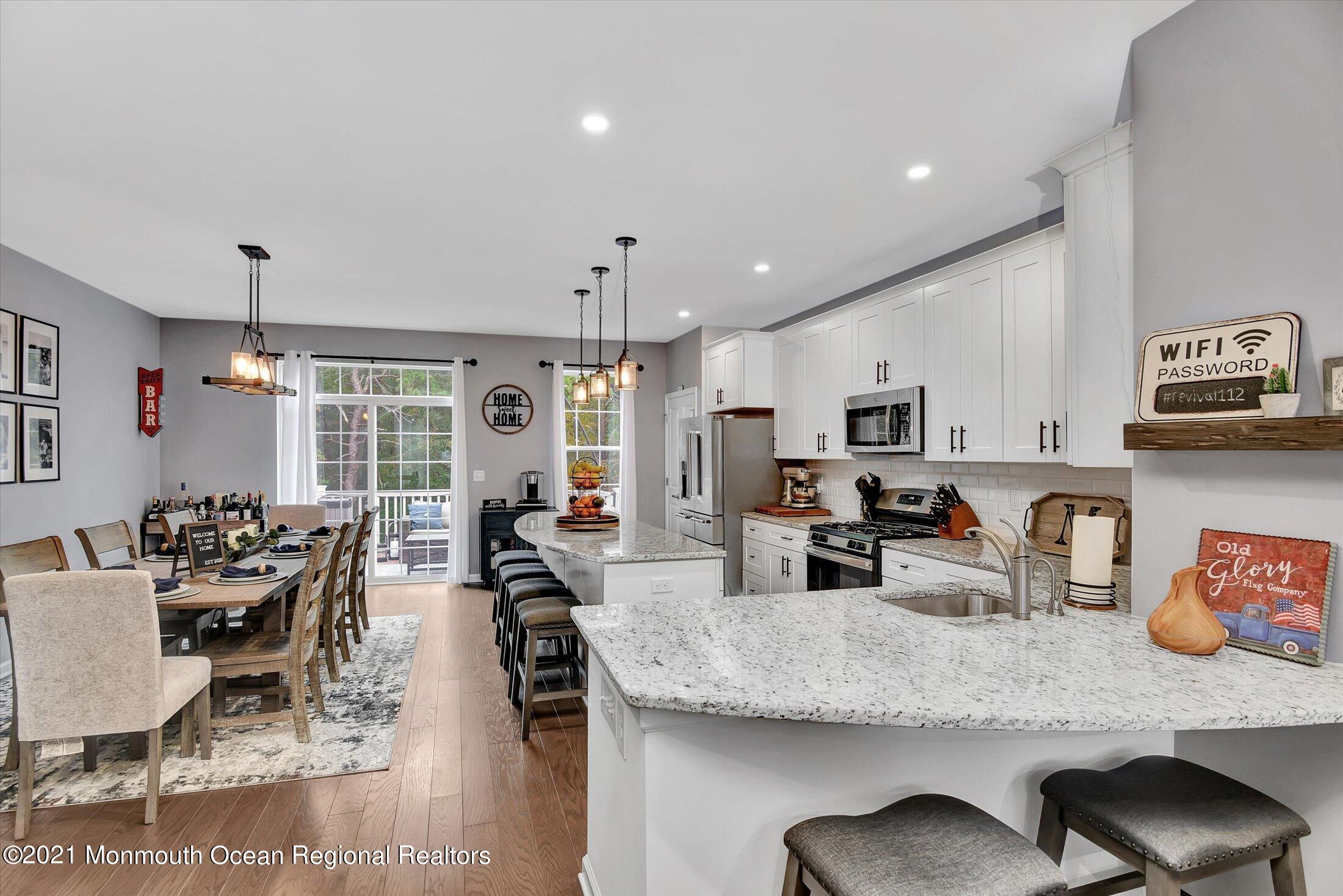 112 Revival Road, Unit 2012 Brick, NJ 08723 - Photo 2 of 22 a kitchen with stainless steel appliances granite countertop a dining table chairs stove and white cabinets
