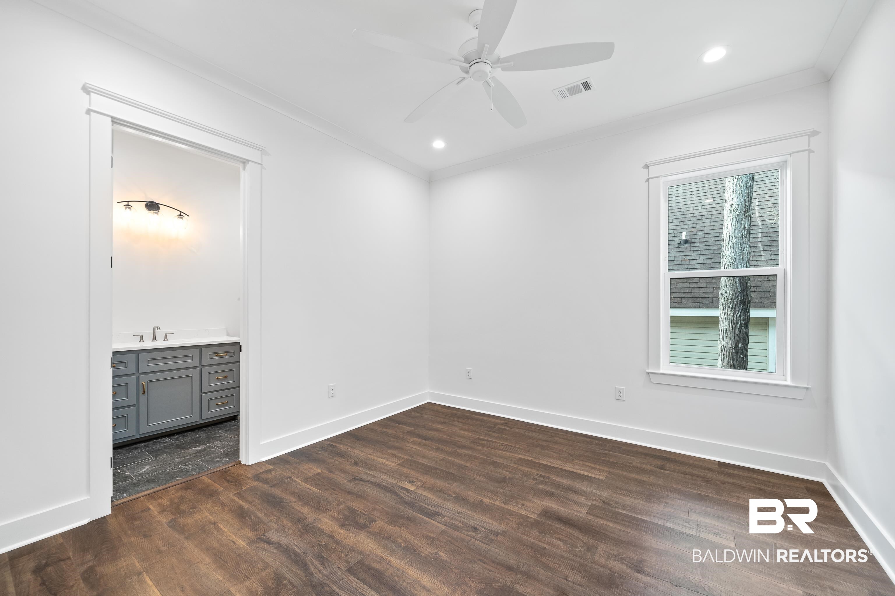 12453 County Road 1 Fairhope, AL 36532 - Photo 18 of 33 Empty room featuring ornamental molding, dark wood-type flooring, and sink