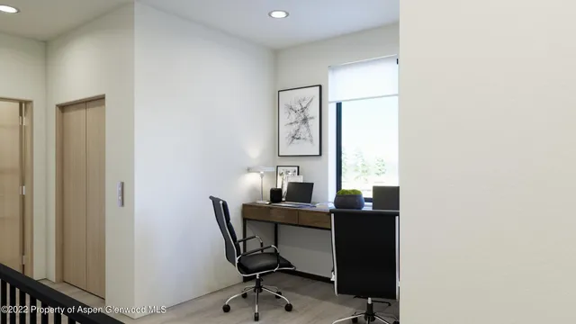 a view of a workspace with furniture and a window