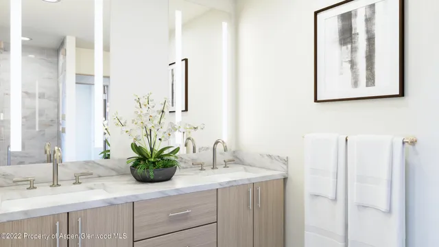 a bathroom with a sink a mirror and a potted plant