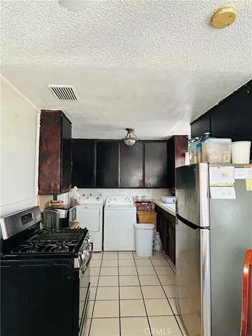 a kitchen with stainless steel appliances granite countertop a refrigerator a stove and a sink with wooden cabinets