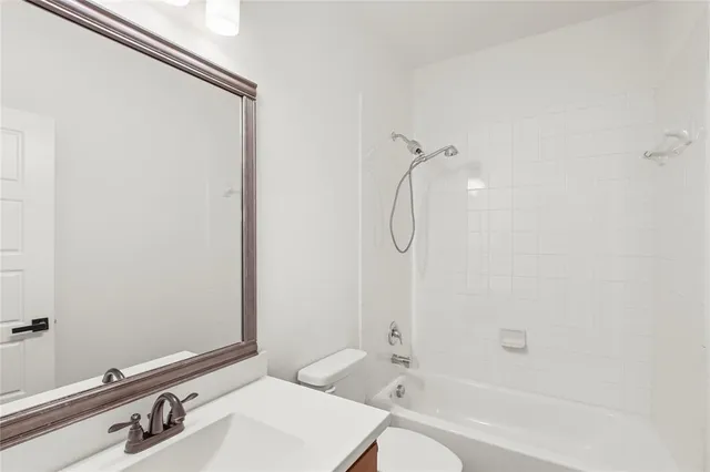 a bathroom with a granite countertop sink a mirror and a bathtub