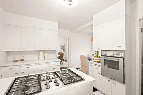a kitchen with white cabinets and appliances