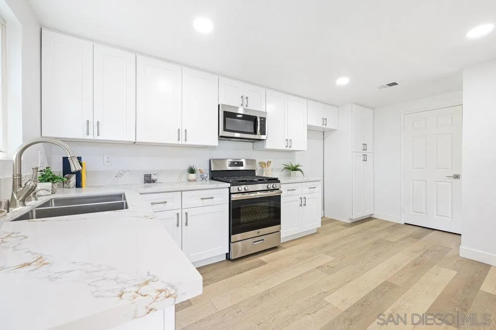 1636 Arabian Way Oceanside, CA 92057 - Photo 10 of 21 a kitchen with granite countertop white cabinets and stainless steel appliances