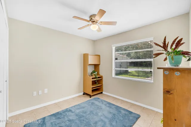 an empty room with window and a ceiling fan