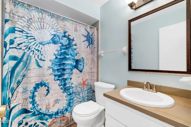 a bathroom with a sink mirror vanity and toilet