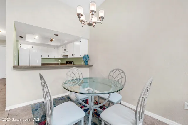 a view of a dining room with furniture a chandelier and wooden floor