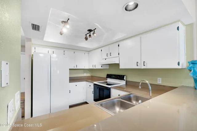 a kitchen with stainless steel appliances granite countertop a sink refrigerator and cabinets
