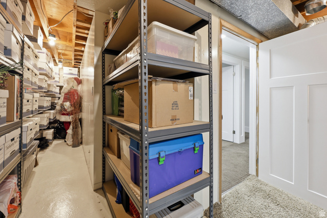 2342 Charros Road Sandy, UT 84092 - Photo 64 of 94 Dedicated storage area featuring open metal shelving, painted concrete flooring, and exposed ceiling joists
