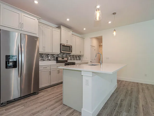 a kitchen with kitchen island a sink stainless steel appliances and cabinets