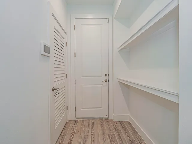 a view of a hallway with wooden floor