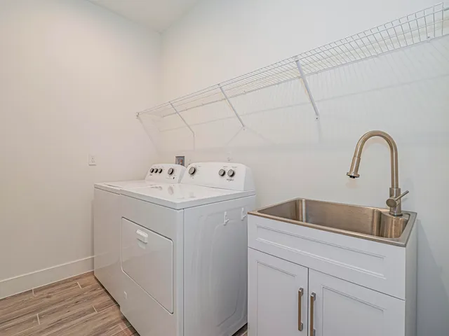 a utility room with sink dryer and washer