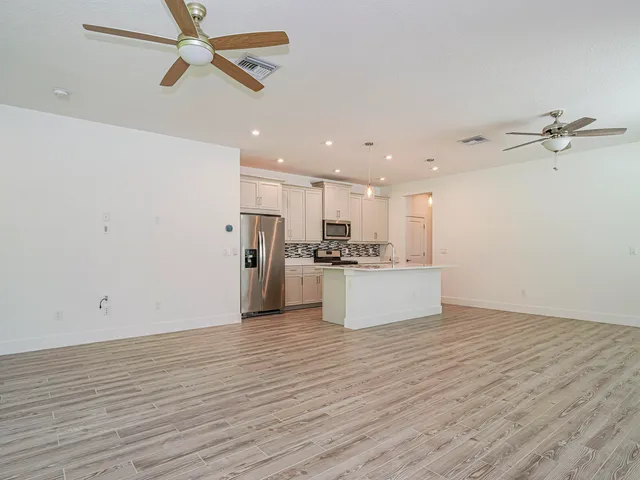 a view of kitchen with stainless steel appliances a refrigerator stove top oven and cabinets