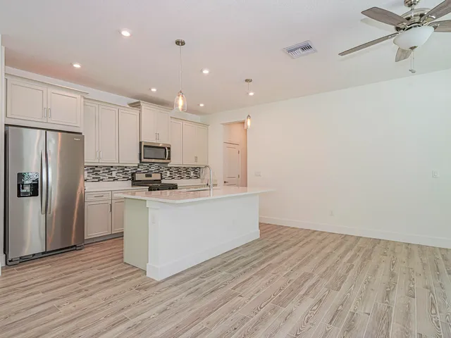 a kitchen with white cabinets and stainless steel appliances