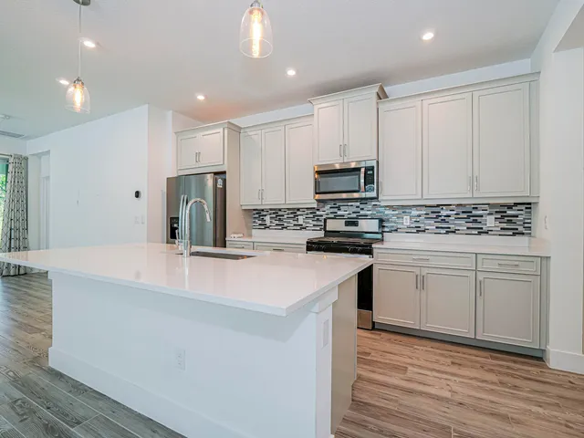 a kitchen with kitchen island white cabinets appliances and cabinets