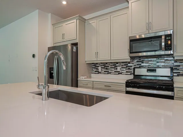 a kitchen with stainless steel appliances granite countertop a stove a microwave and a sink