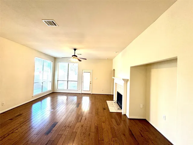a view of a livingroom with a fireplace a chandelier and wooden floor