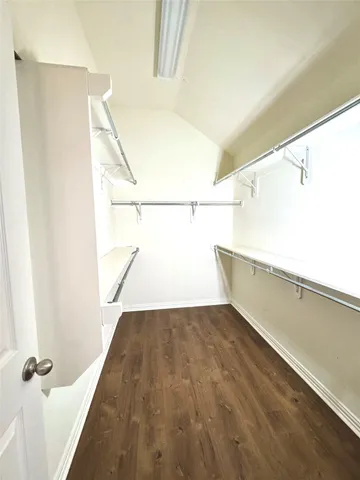 a view of a hallway with wooden floor and closet