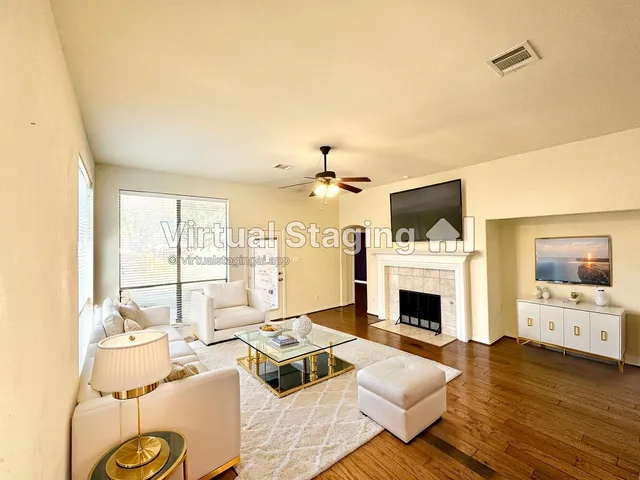 an empty room with wooden floor fireplace and windows