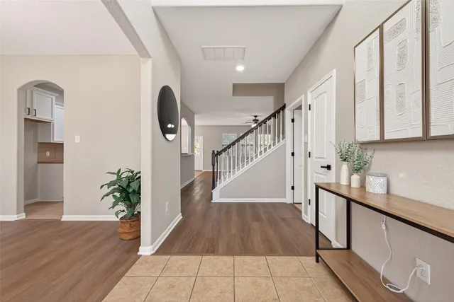 a view of an empty room with a window and kitchen view