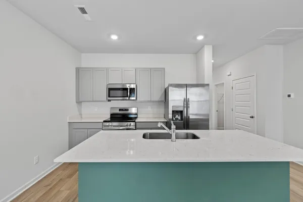 a kitchen with kitchen island stainless steel appliances a sink stove and refrigerator