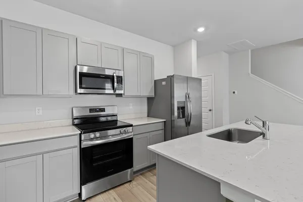 a kitchen with a sink a stainless steel appliances and cabinets
