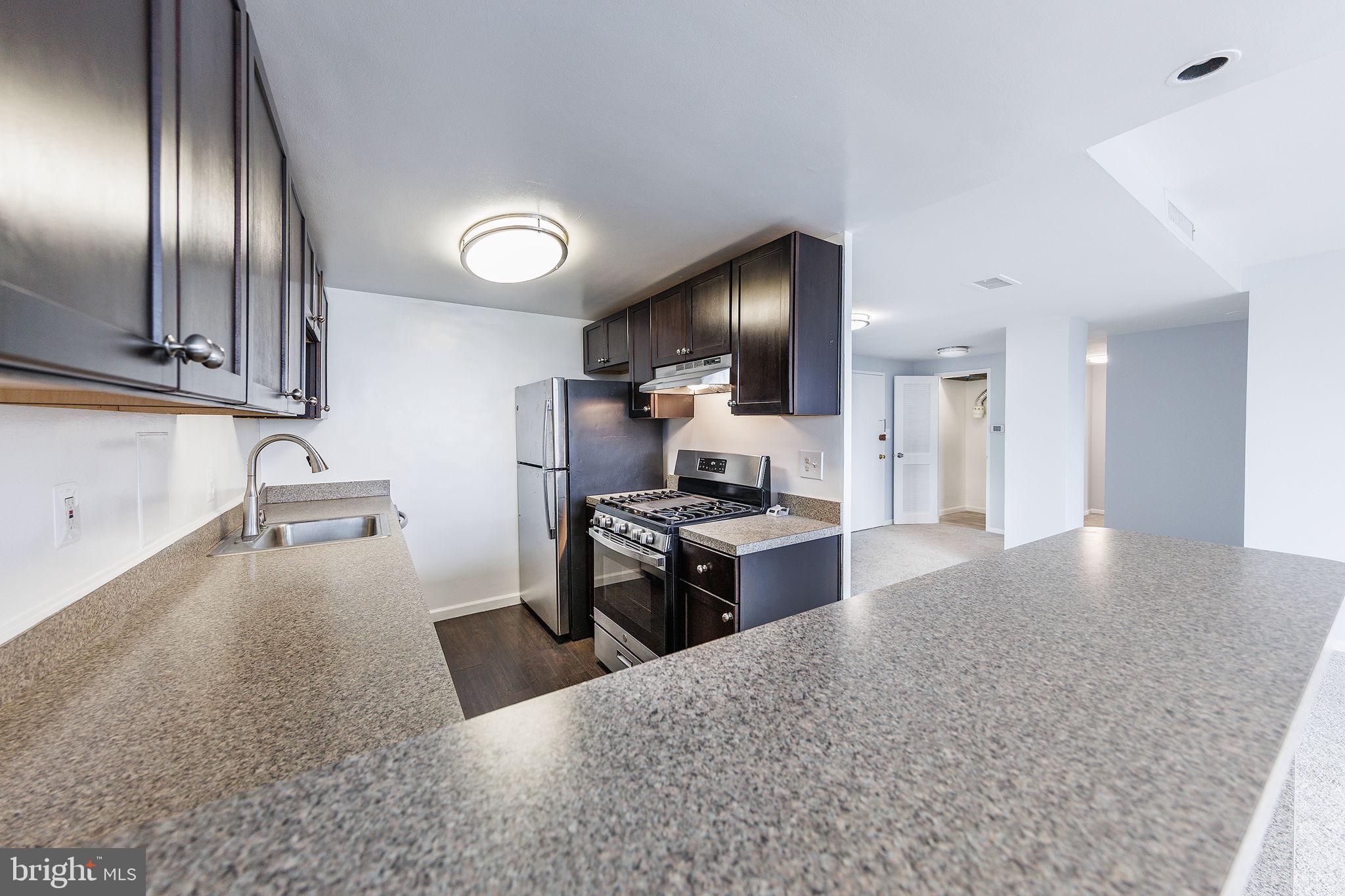 4600 Duke Street, Unit 622 Alexandria, VA 22304 - Photo 6 of 52 a kitchen with stainless steel appliances granite countertop a sink stove and refrigerator