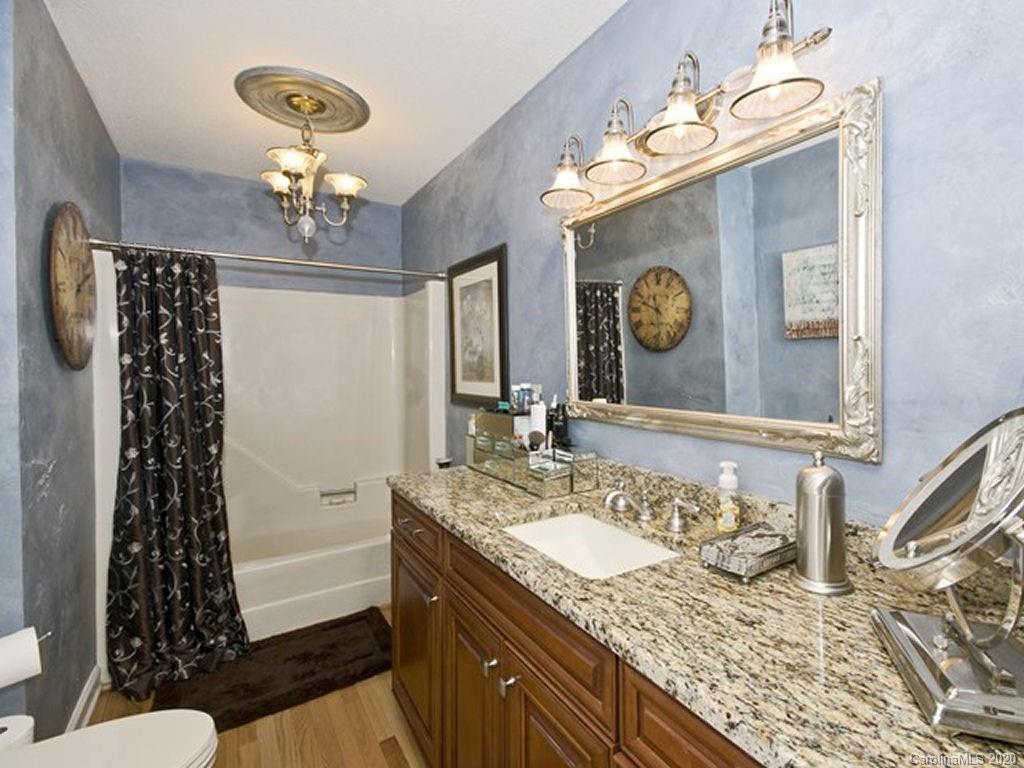 82 Gregg Roost Road Sylva, NC 28779 - Photo 26 of 35 a bathroom with a granite countertop sink a mirror and shower