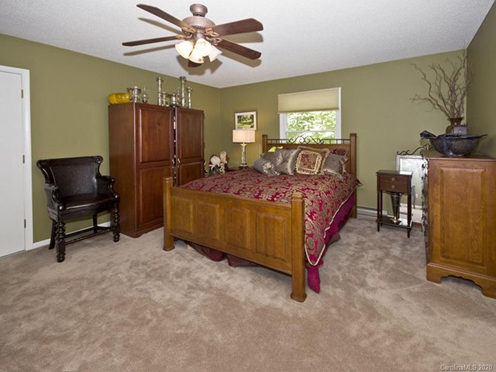 82 Gregg Roost Road Sylva, NC 28779 - Photo 31 of 35 a bedroom with a bed and a chandelier