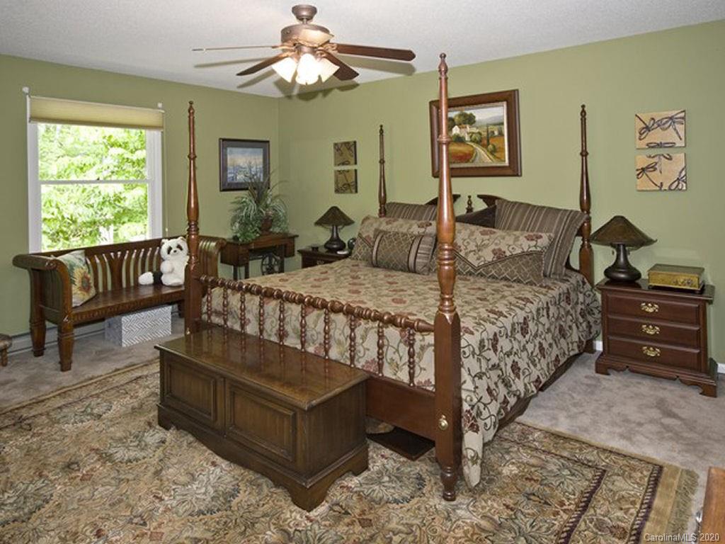 82 Gregg Roost Road Sylva, NC 28779 - Photo 32 of 35 a bedroom with a bed and a chandelier